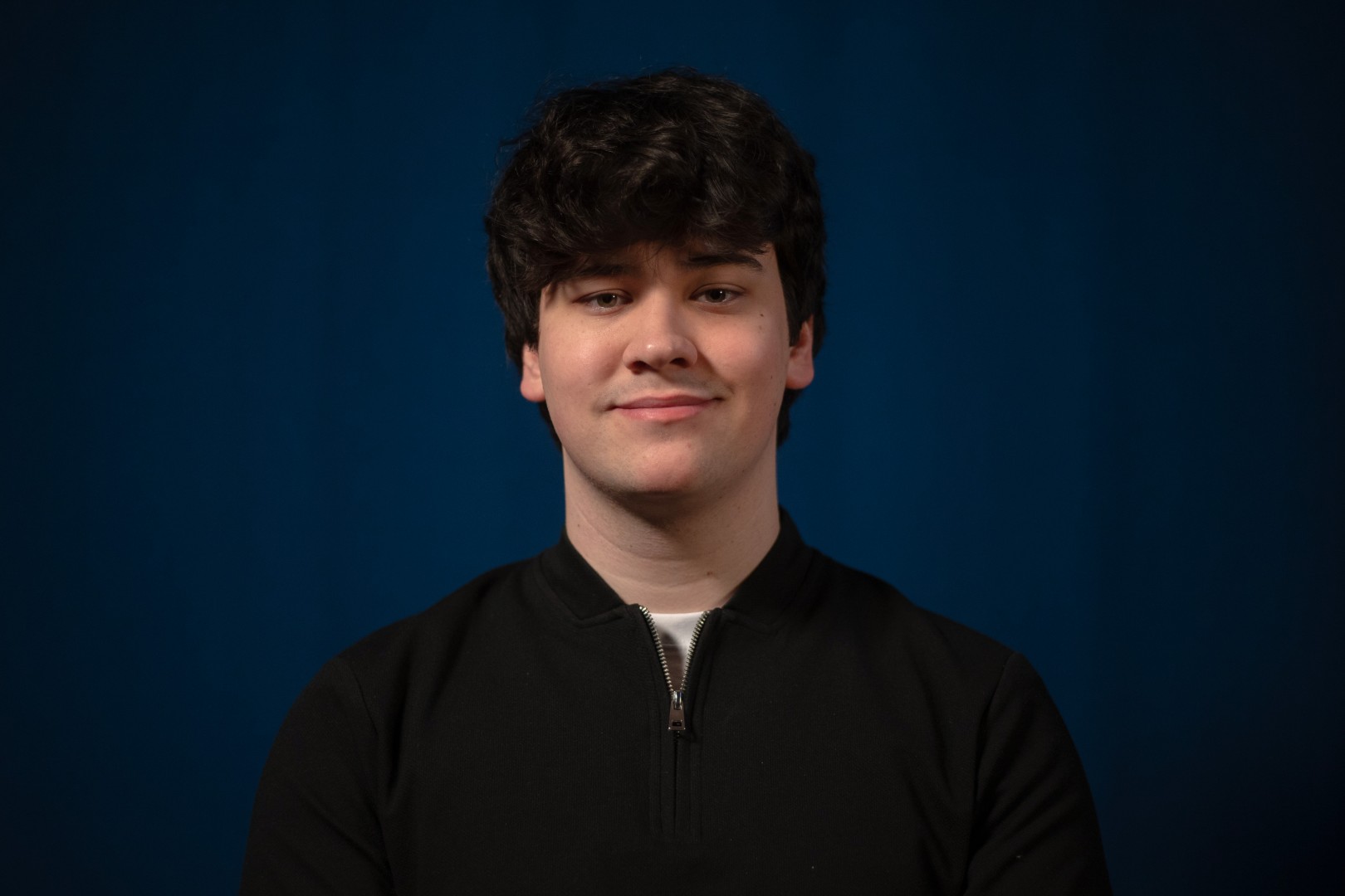 Headshot of Ollie Slade, owner of Slade Web Solutions, smiling in a black quarter zip.